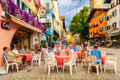 Tourists sitting in street restaurant in Kitzbuhel town, Tirol, Austria. This place is famous holiday destination in Summer season