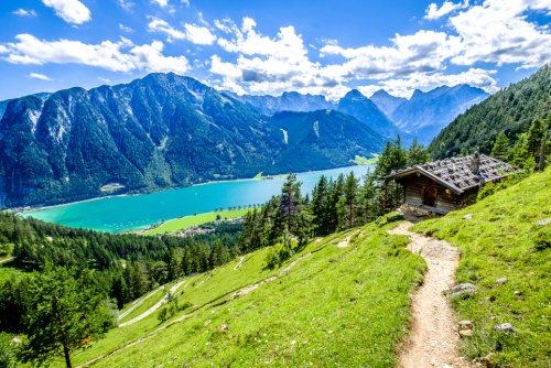 A pathway and view from above of lake Achensee and the Alps in the background in Tirol, Austria