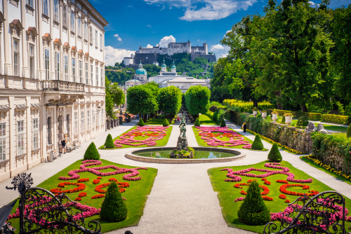 View of the beautiful gardens at the Mirabell Palace and Gardens in Summer, Salzburg castle in background, Austria