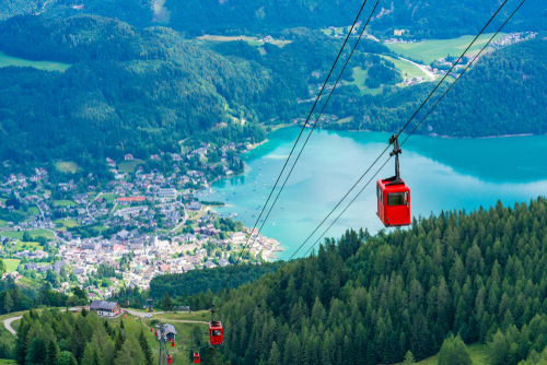 View of St. Gilgen village, Wolfgangsee lake and red Seilbahn cable car gondolas from Zwolferhorn mountain in Salzkammergut region, near Salzburg, Austria
