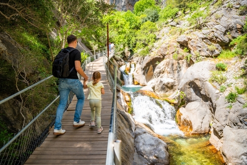Father with little girl hiking in Sapadere canyon with wooden paths and cascades of waterfalls in the Taurus mountains, near Alanya, Antalya, Turkey