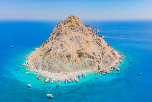 Aerial view of Suluada island with white sand and boats sorrounding the iland, Antalya, Turkey