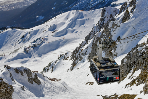 High angle view from the summit of Nordkette mountain towards the mid-station and cable car or gondola just arriving on the top, Innsbruck, Tirol, Austria