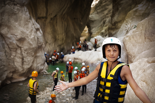 Young athlete is glad to the victory in competition of overcoming hard mountain river in Goynuk canyon in mountain range of Central Taurus, Kemer, Antalya, Turkey