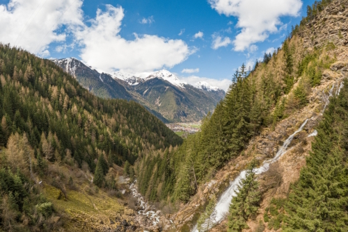 Early springtime view of the Oetztal valley, seen from Stuibenfall waterfall in Umhausen. Steep mountains on both sides, valley in the middle. Snocapped mountains in the background, Tirol, Austria