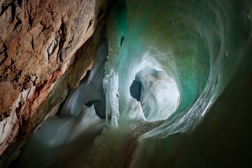 Ice Formations in a big ice cave “Eisriesenwelt“ in the Austrian alps is a tourist attraction near Salzburg and Werfen with green reflections in the frozen waterfall underground and limestone rock, Austria