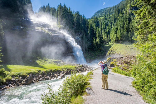 Man taking a photo of the Krimml Waterfalls near Salzburg, Austria
