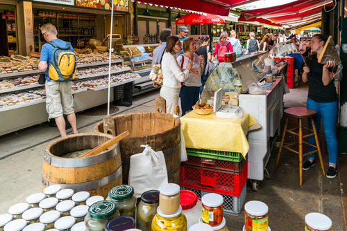 People buying food at market stands in Naschmarkt in Vienna, Austria