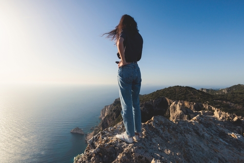 Woman looking from a viewpoint where the Angelokasto Castle is situated near Palaiokastritsa and Krini, Corfu Island, Ionian sea, Central Corfu and Diapontia Islands, Greece