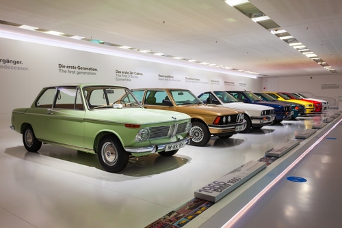 Row of classic to modern BMW car series on display in BMW Museum, an automobile museum of BMW history located near the Olympiapark in Munich, Bavaria, Germany