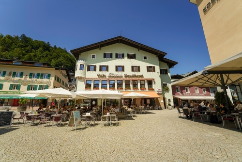Berchtesgaden Marktplatz, a cafe restaurant in the main square in the traditional alpine German Town in the Bavarian Alps with people eating, drinking