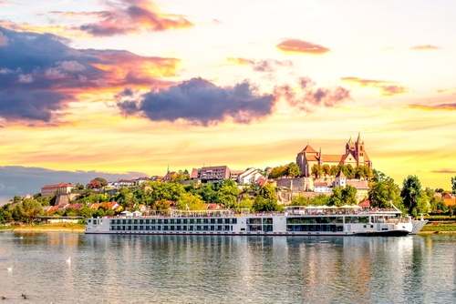 View of Breisach from the Rhein river with dramatic skies in the background with a river cruise boat at the center, The Black Forest, Baden-Württemberg region of Germany