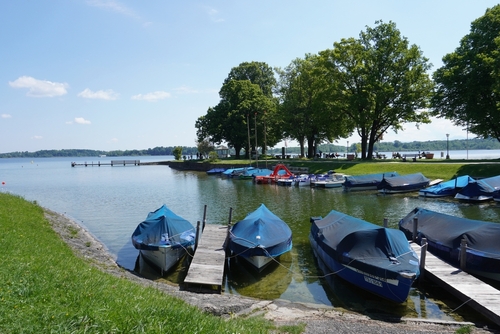 Beautiful view over Lake Chiemsee in Bavaria with jetty and boats on the shore in Bavaria, Germany