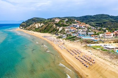 Aerial view of Agios Stefanos beach and its facilities, it is a small tourist resort on the Northeast coast of Corfu Island, Ionian Islands, Greece