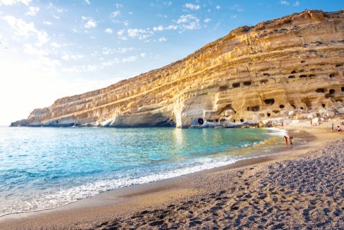 Matala beach with caves on the rocks that were used as a Roman cemetery and at the decade of the 1970s were living hippies from all over the world, Island of Crete, Greece