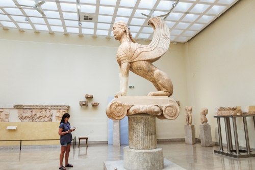 The mythical Sphinx of Naxos statue stands on the pedestal in the Archaeological museum in Delphi, near Athens, Attica, Greece