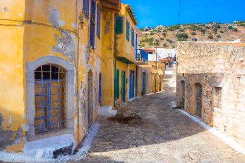 Narrow cobbled-street with colorful stone houses in old village of Pano Elounda, near Agios Nikolaos, Lasithi, Island of Crete, Greece