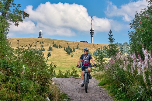 Nice senior woman on her electric mountain bike cycling on Feldberg summit, The Black Forest, Baden-Wuerttemberg, Germany
