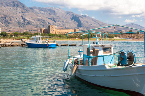 Fishing boats in a small port in front of the Venetian Fortress of Frangokastello on the South coast of the Island of Crete, Greece