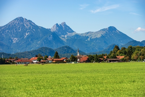 Green Agricultural Fields and Bavarian Alps with the small town of Schwangau near Fussen, Ostallgau, Bavaria, Germany