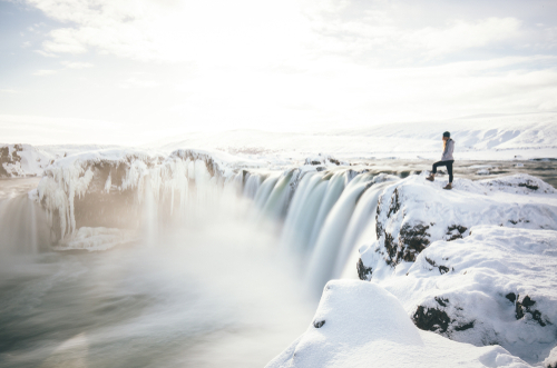 A person looking out over Goðafoss Waterfall in north Iceland, in Winter
