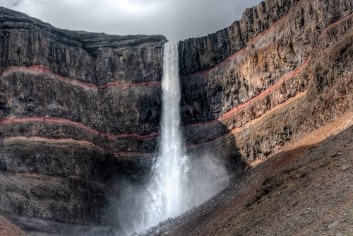 Beautiful view of Hengifoss Waterfall. Hengifoss, is eye-catching due to the striking red clay and black basalt patterns on the cliff face. Fljótsdalshreppur, east Iceland
