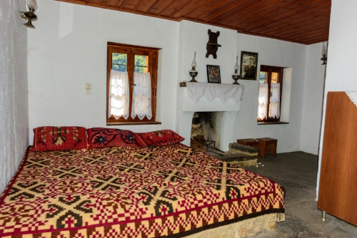 Bedroom with stone bed and fireplace in Holy Kipinas Monastery in Tzoumerka mountainous region, Ioannina, Epirus, Greece. The complex was built in 1212