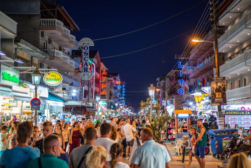 Scenic nightlife view of the seaside town Paralia Katerini near the Olympic Coast with people walking along the pedestrian streets in the Summer in Pieria, Macedonia, Greece