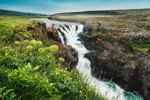 Landscape of Kolugljufur Canyon rapids flowing with tourist enjoying in Vididalur valley during summer at Northern Iceland