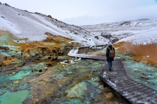 A tourist woman on the path of colorful Krysuvik seltun on reykjanes peninsula in Iceland