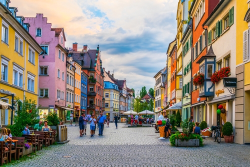 People are strolling through the main street with colorful houses in Lindau im Bodensee, Bavaria, Germany