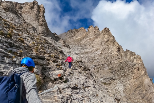 Couple climbing on mystical foggy hiking trail leading to Mount Olympus, Mount Olympus National Park, Thessaly, Greece