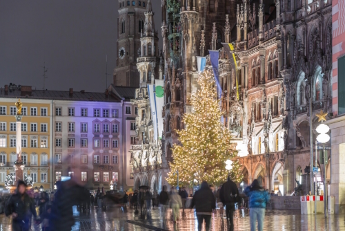 Marienplazt Old Town Square with New Town Hall night timelapse. Neues Rathaus and Town Hall Clock Tower Glockenspiel. Munich skyline, illuminated downtown cityscape during rain. Bavaria, Germany