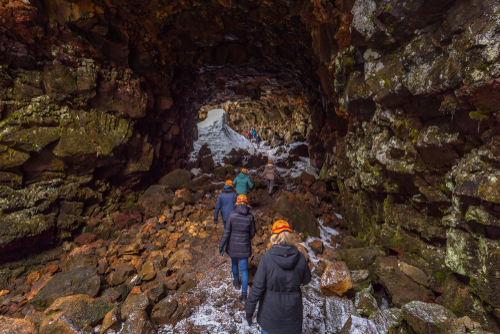 Travelers entering the Raufarholshellir lava tunnels, Iceland