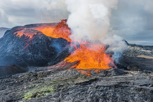 Glowing hot lava with fountain from the volcanic crater on Reykjanes Peninsula. Landscape in Geopark in daylight. strong development of steam over the volcanic crater, Iceland