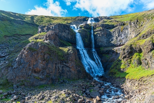 View of Rjukandi waterfalls also called Yst i-Rjukandi with cliffs and waterfalls in Eastern Iceland
