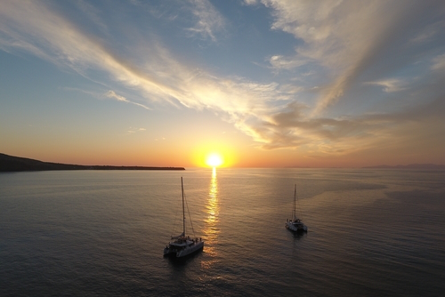 Beautiful sunset boat cruise near Oia on the Island of Santorini, Cyclades Islands, Greece