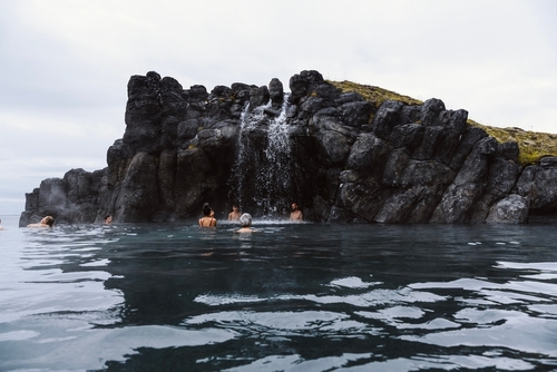 Sky Lagoon in Iceland. Tourists enjoying geothermal SPA with heated water during cold day