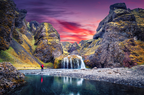 Amazing Icelandic Landscape. Photographer standing on canyon of river before majestic Stjornarfoss Waterfall near Kirkjubaejarklaustur, Iceland
