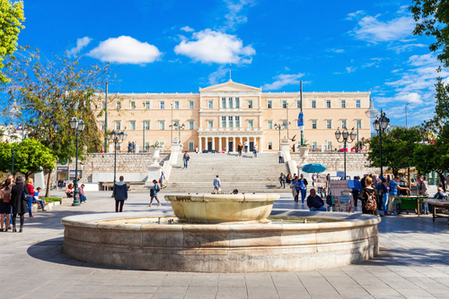 People walking around the Hellenic Parliament building on Syntagma Square in Athens, Greece