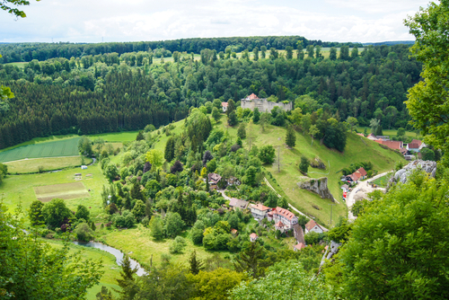 Scenic view of a green river valley & forested hills near the village of Gundelfingen. This beautiful countryside is part of the UNESCO Biosphere Reserve Swabian Alb, the Black Forest, Baden-Wurttemberg, Germany