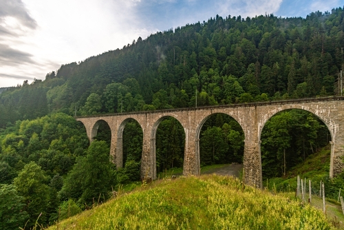 The historic railway bridge with a yellow train at the Ravenna Gorge in the Hell Valley in the Black Forest, Germany