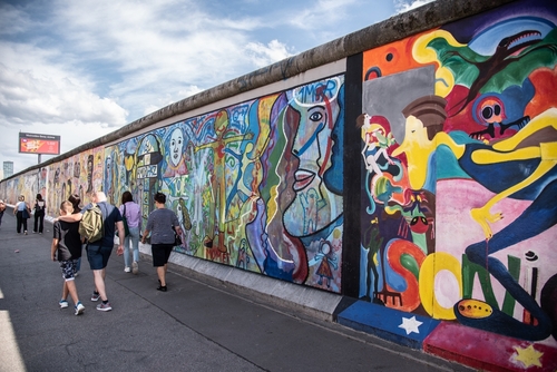People walking around the Berlin Wall or Berlin Mauer, East Side Gallery Street Art Berlin, Germany