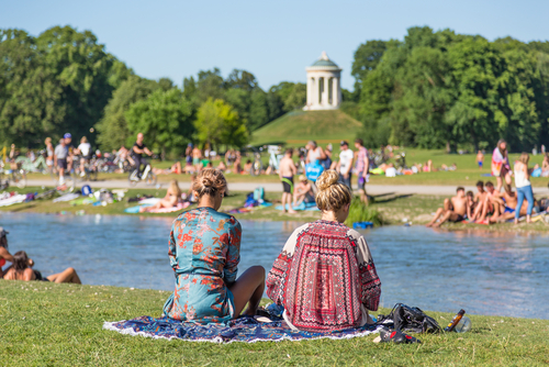 People enjoying the Summer, sunbathing, swimming in river Izar and relaxing on green of the Englischer Garten in Munich, Bavaria, Germany