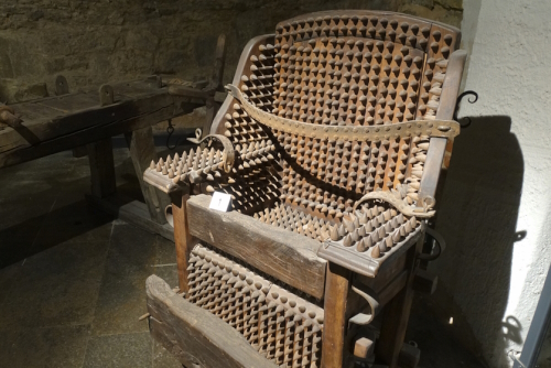 Wooden chair of torture displayed in the Medieval Crime Museum (Mittelalterliches Kriminalmuseum) in Rothenburg ob der Tauber, Germany