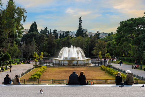 The marble fountain in front of the Zappeion Hall neoclassical building in the National Garden of Athens, Attica, Greece near Syntagma Square. People relaxing under the sun