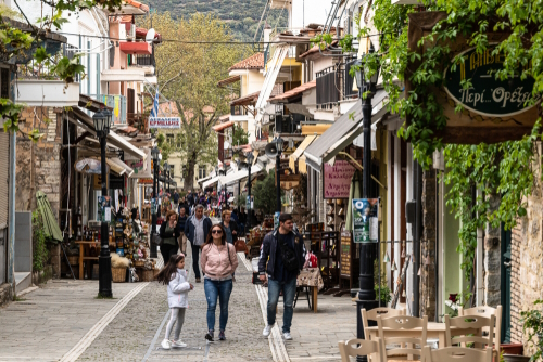 Tourists and local people walk in a pedestrian street in the mountain village of Kalavryta in the Peloponnese, Greece