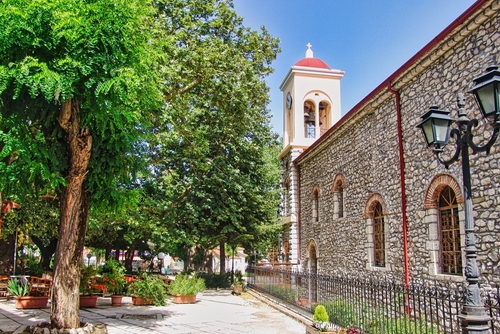 Main square of the beautiful city of Kalavryta in the Peloponnese, Greece, with trees and a church
