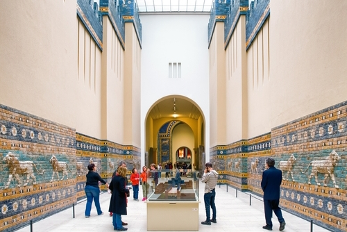 Tourists inside Pergamon museum looking on Lion mosaic from Ishtar Gate from Ancient Babylon, Berlin, Germany