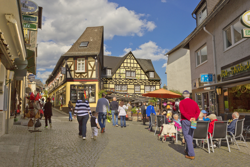 People walking through the central street in the small town of Ruedesheim am Rhien with half-timbered hourse, located in the Rhine Valley in Rhineland-Palatinate, Germany